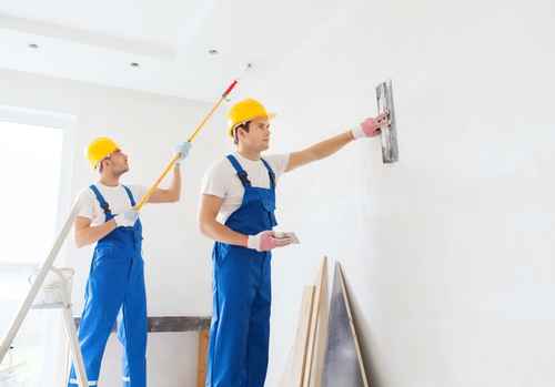 group of builders with tools indoors